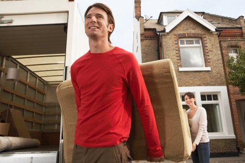 Local removals team handling furniture in a Streatham street