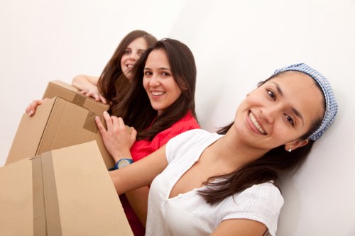 Movers carrying office furniture through a Streatham building entrance